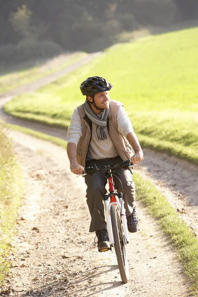 Nuori mies ajaa hänen pyörä puistossa — kuvapankkivalokuva