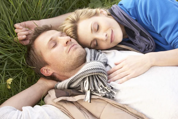 Mladý pár spolu leží na trávě — Stock fotografie