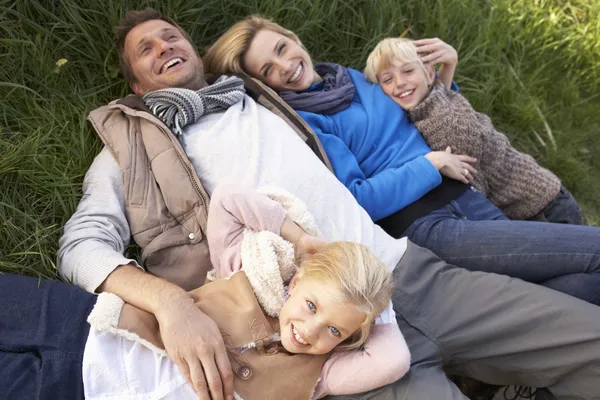 Młode rodziny razem leżąc na trawie — Zdjęcie stockowe