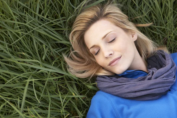 Mujer joven durmiendo sola en la hierba —  Fotos de Stock