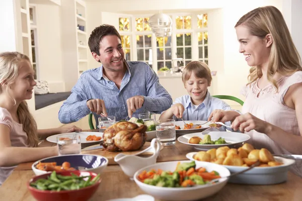 Bonne famille ayant le poulet rôti dîner à table — Photo