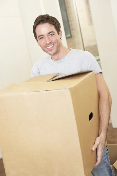 Young man on moving day holding and carrying cardboard box — Stock Photo, Image