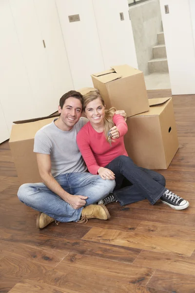 Jeune couple le jour du déménagement assis avec des boîtes en carton — Photo