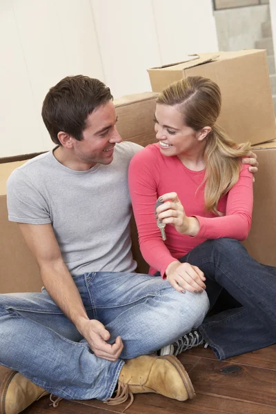 Young couple on moving day sitting with cardboard boxes — Stock Photo, Image