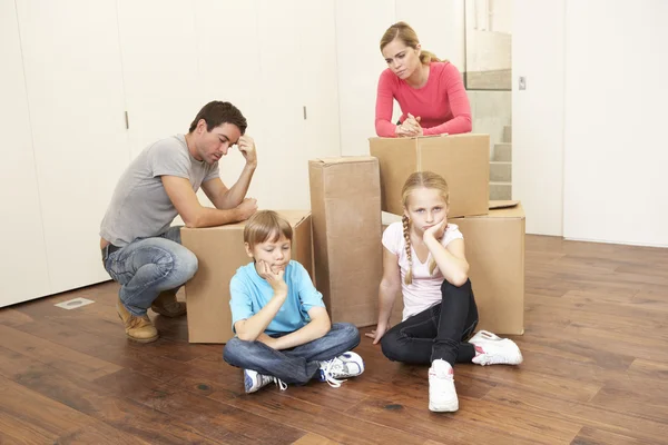 Молода сім'я виглядає засмученою серед коробок — стокове фото