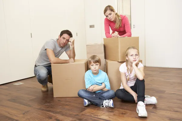 Junge Familie blickt aufgeregt zwischen Kisten — Stockfoto