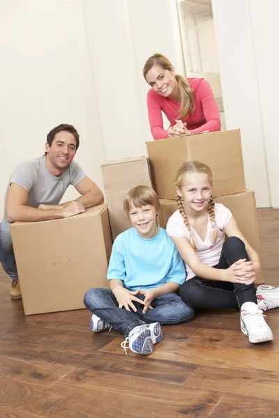 Молодая семья в день переезда выглядит счастливой среди коробок — стоковое фото