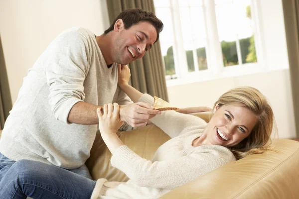 开心的年轻夫妇在沙发上笑 — 图库照片