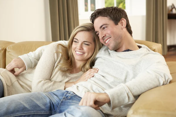 Giovane coppia seduta e rilassante sul divano — Foto Stock