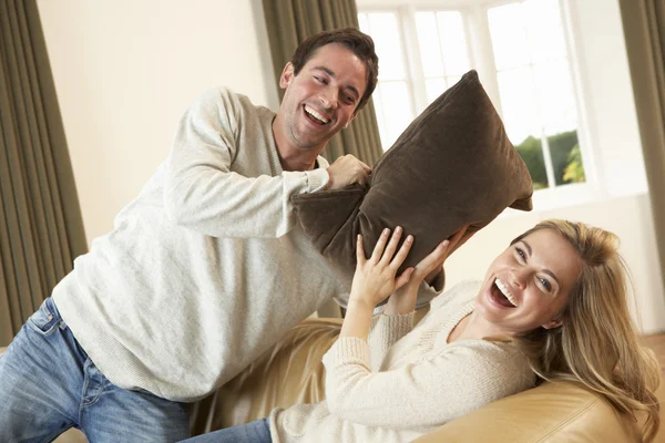 Молода пара весело сміється на дивані — стокове фото