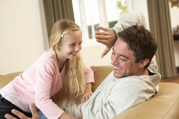 Jovem pai com menina se divertindo no sofá — Fotografia de Stock