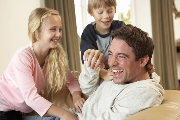 Jovem pai com crianças se divertindo no sofá — Fotografia de Stock