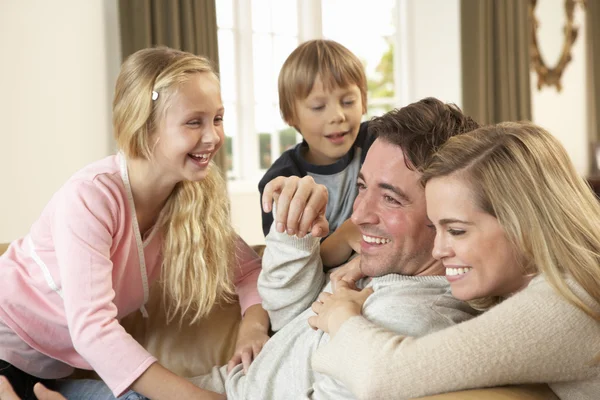 Felice giovane famiglia che gioca insieme sul divano — Foto Stock