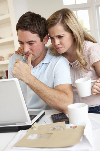 Casal jovem pensando e olhando para um computador portátil — Fotografia de Stock