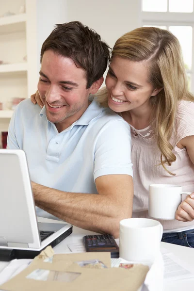 Feliz joven feliz pareja mirando y leyendo una computadora portátil — Foto de Stock