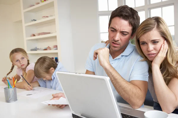 Junges Paar denkt und schaut auf einen Laptop — Stockfoto