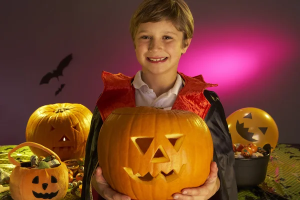 Festa de Halloween com um menino segurando abóbora esculpida — Fotografia de Stock