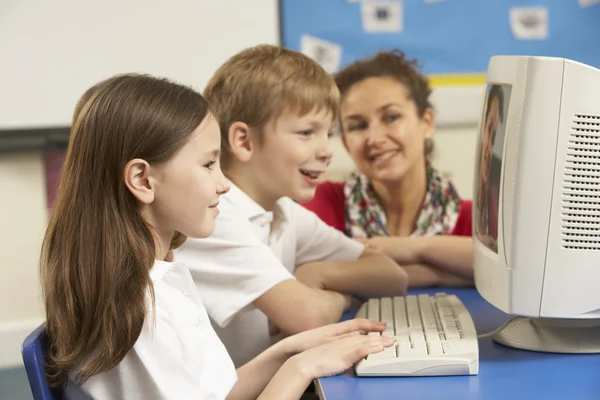 Los escolares en la clase de TI utilizando la computadora con el maestro —  Fotos de Stock