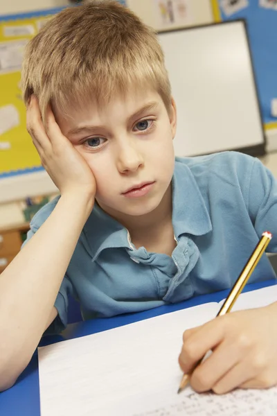 Stressed Schoolboy Studying In Classroom — Stock Photo, Image