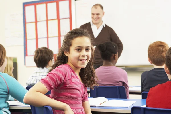 Crianças em idade escolar estudando na sala de aula com professor — Fotografia de Stock
