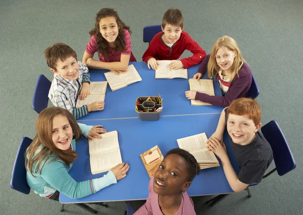 Översiktsbild av skolbarn som arbetar tillsammans vid skrivbord — Stockfoto