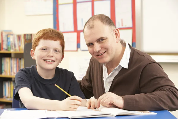 Male Pupil Studying in classroom with teacher — Stock Photo, Image