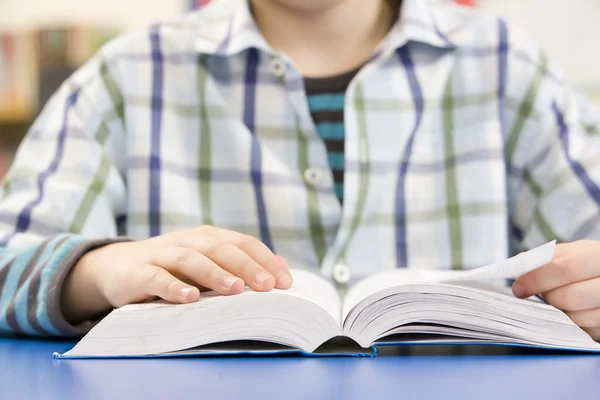 Close up van schooljongen studeren leerboek in klas — Stockfoto