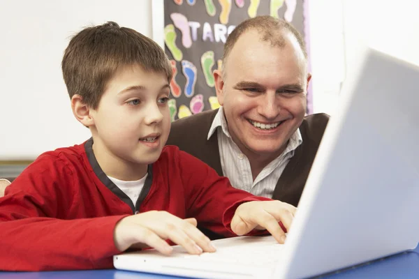 Skolpojke i den klass dator med lärare — Stockfoto