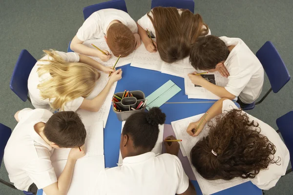 Visão aérea de crianças em idade escolar que trabalham juntas na mesa — Fotografia de Stock