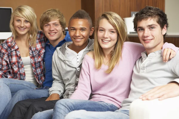 Grupo de amigos adolescentes sentados no sofá em casa — Fotografia de Stock