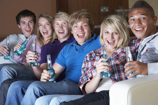 Grupo de amigos adolescentes sentados no sofá em casa assistindo Drinki — Fotografia de Stock