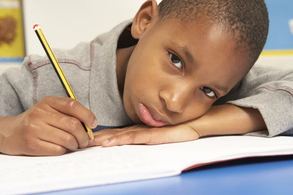 Unhappy Schoolboy Studying In Classroom Stock Image