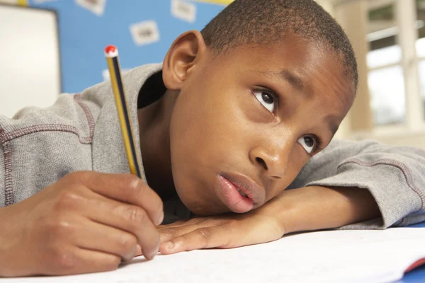 Unhappy Schoolboy Studying In Classroom Stock Picture