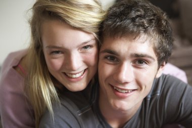 Romantic Teenage Couple Smiling At Camera clipart