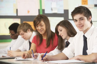 Teenage Students Studying In Classroom With Teacher clipart