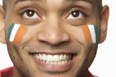 Young Male Sports Fan With Ivory Coast Flag Painted On Face clipart