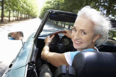 Senior woman in sports car clipart