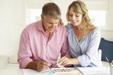 Mid age couple painting with watercolors clipart