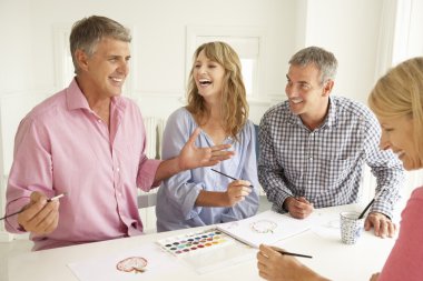 Mid age couples painting with watercolors clipart