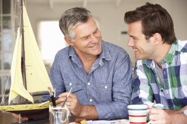 Adult father and son model making clipart
