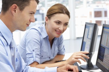 Businessman and woman working on computers clipart