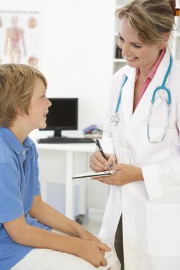 Female doctor talking to young boy clipart