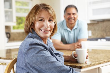 Senior couple relaxing in kitchen clipart