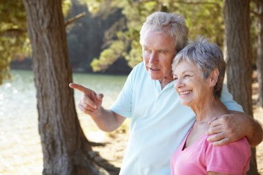 Senior couple at lake together clipart