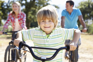 Young family on country bike ride clipart