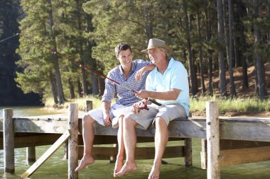 Father and adult son fishing together clipart