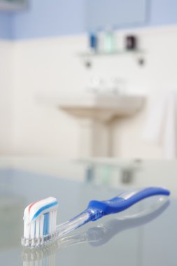 Toothbrush with toothpaste in bathroom clipart