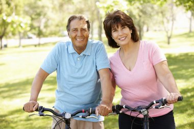 Senior Hispanic couple on bikes clipart