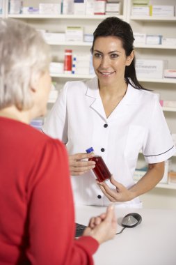 American pharmacist dispensing to senior woman clipart