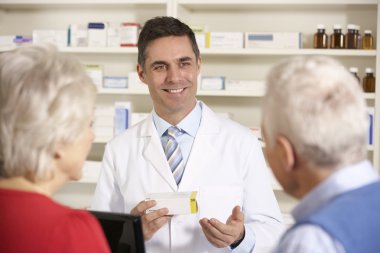 American pharmacist with senior couple in pharmacy clipart